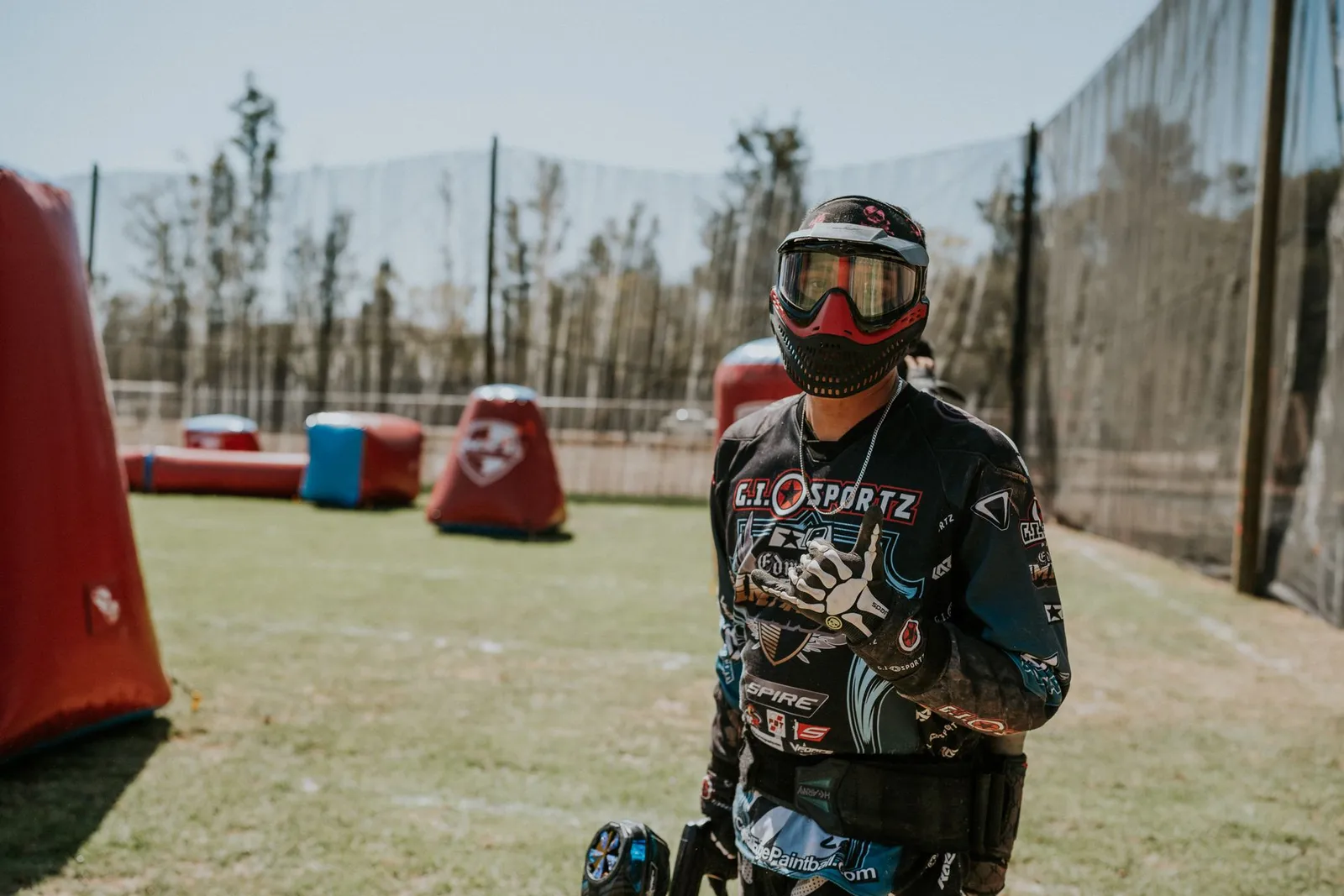 Joueur de paintball en maillot et masque sur un terrain d'obstacles gonflables