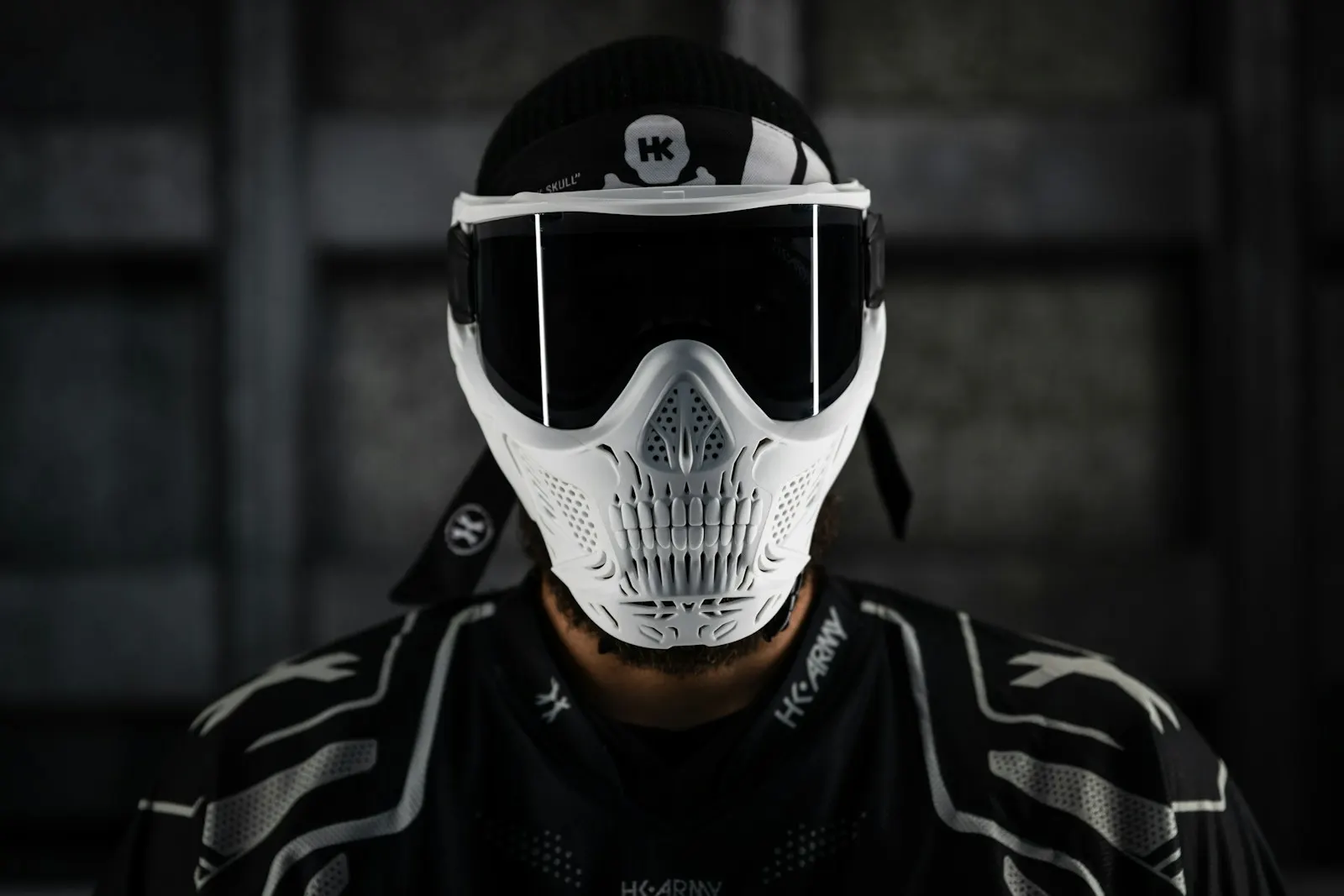 Masque de paintball intégral blanc et noir à écran fumé porté par un joueur