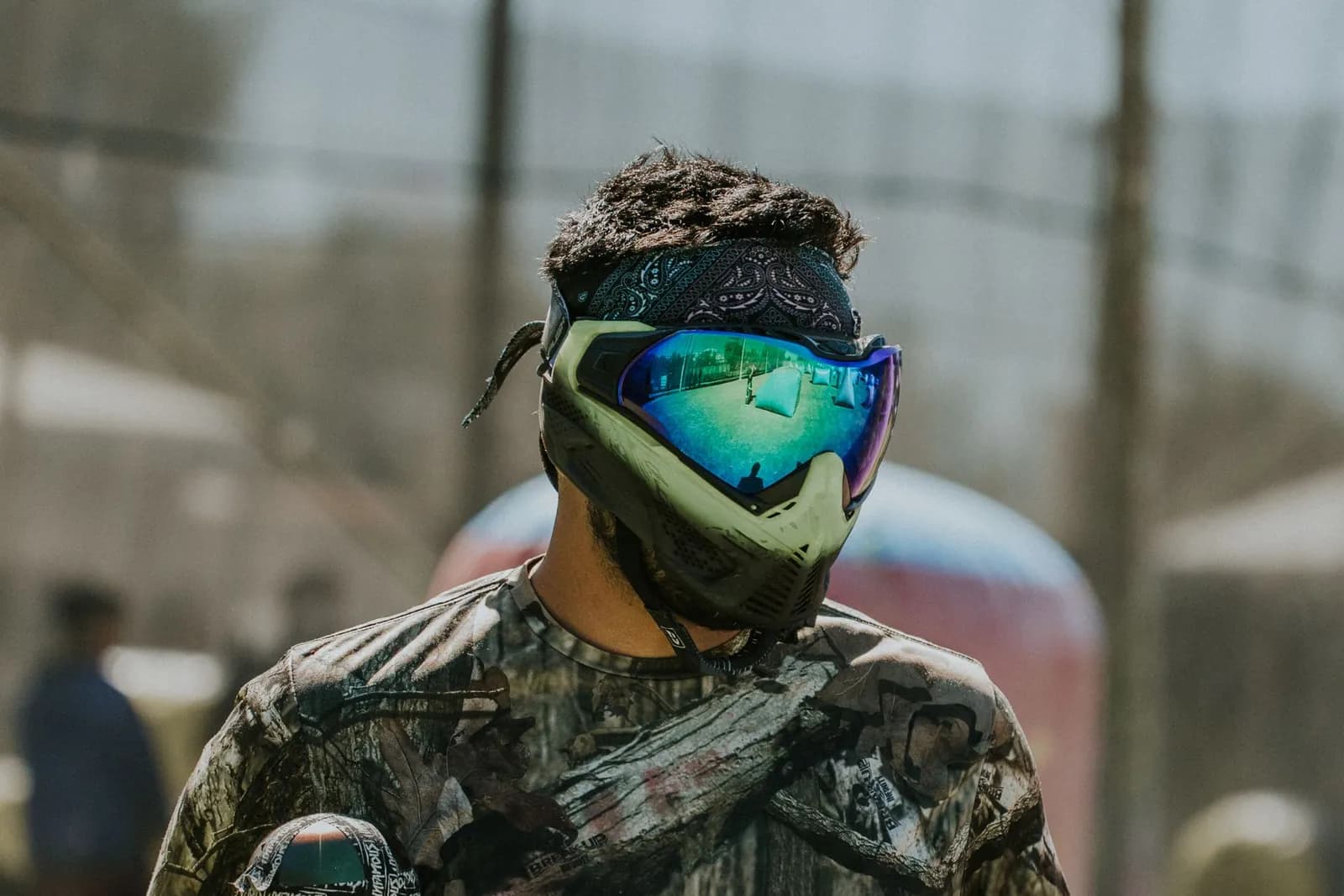 Joueur de paintball en tenue camouflage et masque à écran miroir sur un terrain